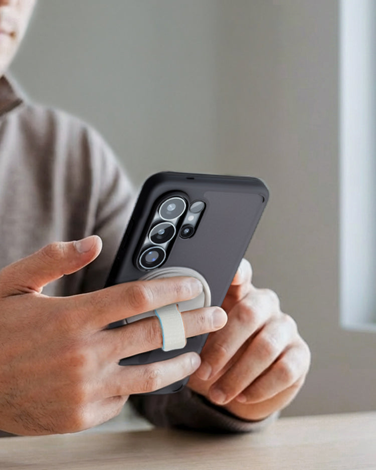 MagFit phone case with magnetic ring grip used by person holding smartphone near window indoors