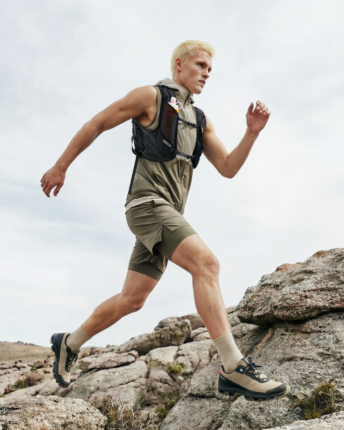 AMP10224 - Dynamic Shield™ Running Vest | A721 M-L in Black worn by a runner climbing rocky terrain outdoors.