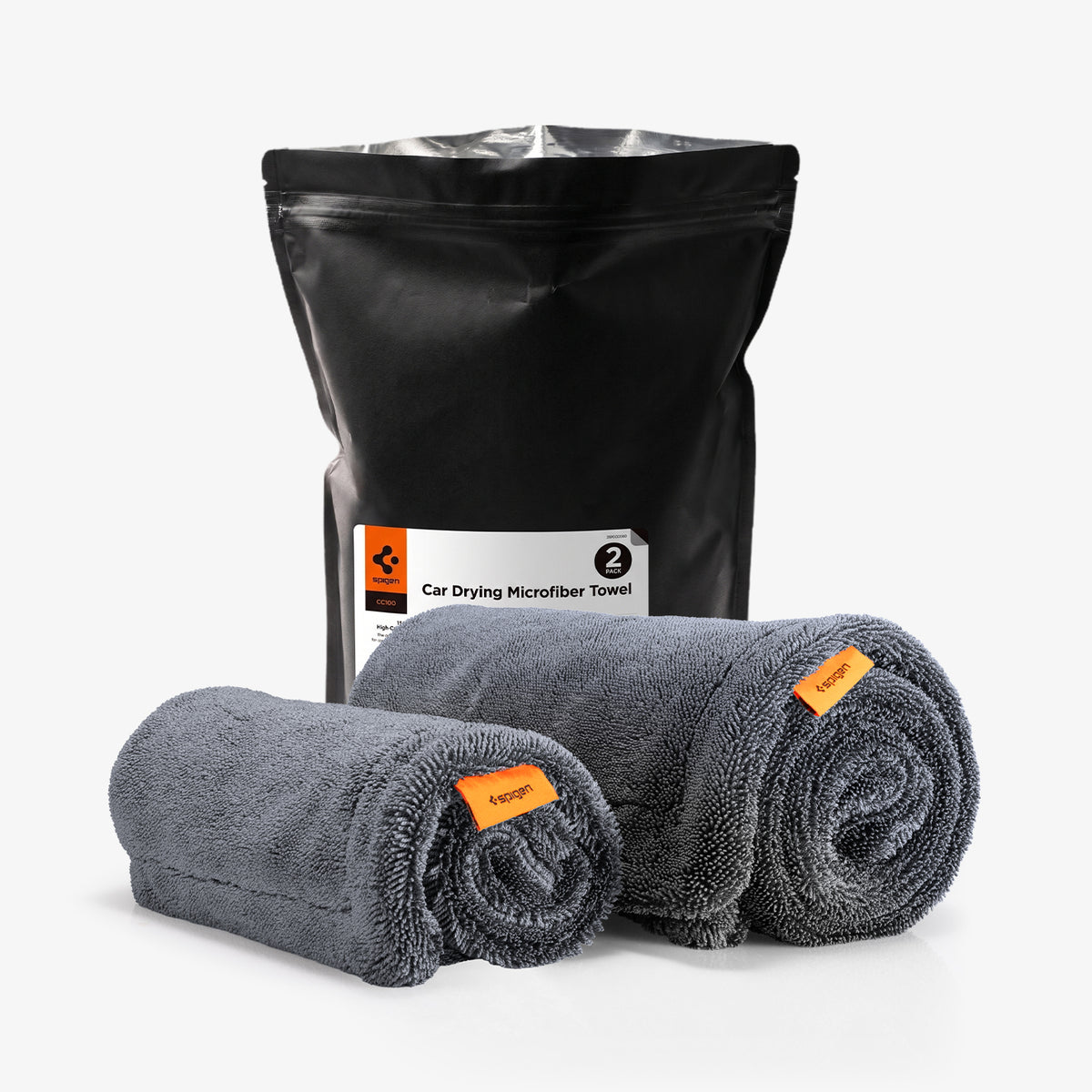 ACP11389 - Spigen CC100 Car Drying Microfiber Towel 2-pack packaging bag next to two rolled gray towels with orange tags