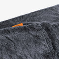 ACP11389 - Close-up of the folded edge of a gray Spigen microfiber car drying towel with an orange brand tag