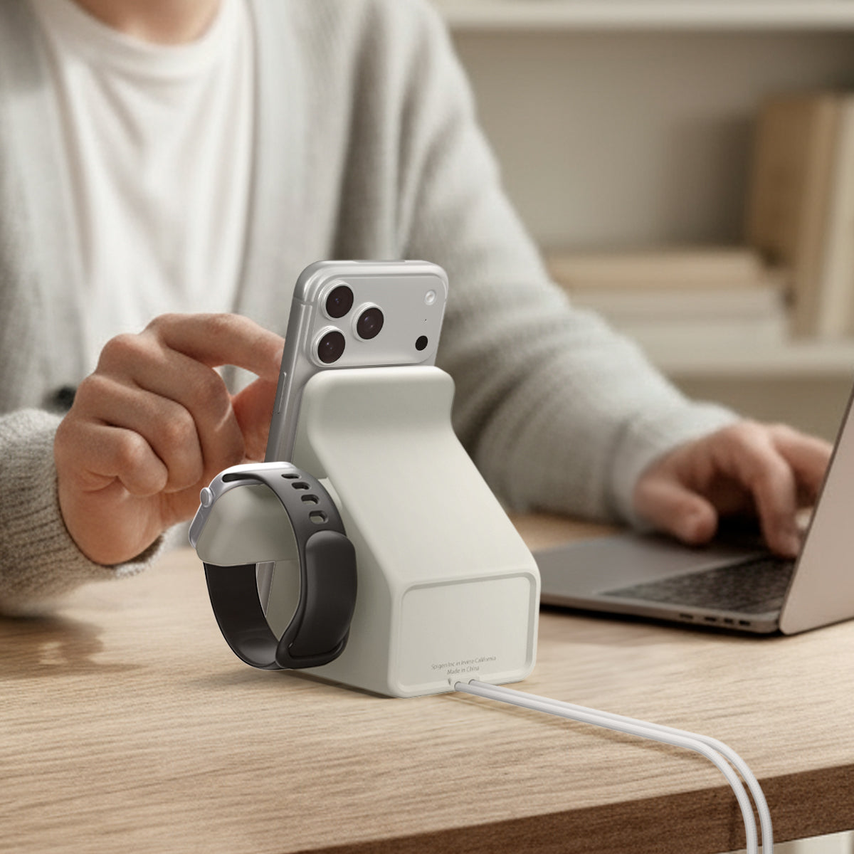 AMP09173 - Magsafe Duo Charger Stand (Mag Fit) in Dune Beige showing a person using the charger stand with the phone and watch attached. 