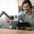 AMP09694 - Phone OneTap Clamp (MagFit) in Space Gray showing a person adjusting the device from the phone holder
