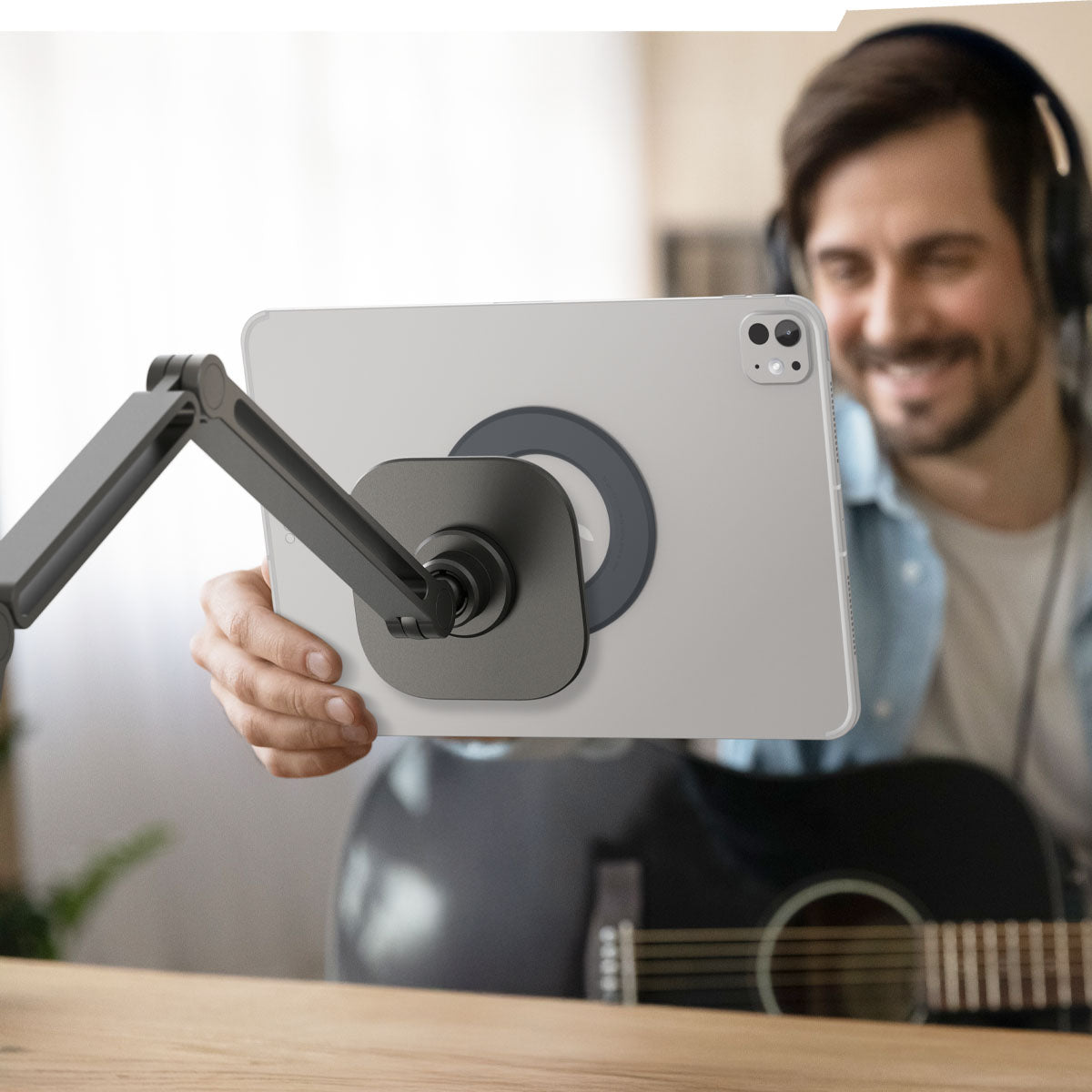 AMP09191 - OneTap Clamp in Space Gray showing a person holding the device, ready to attach it to the clamp stand.