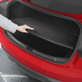ACP11540 - Tesla Series Trunk Sill Guard Hand adjusting the black Spigen scuff plate protector fitted inside a Tesla trunk opening