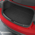 ACP11540 - Tesla Series Trunk Sill Guard Straight-on view of the black Spigen bumper scuff plate installed along a red Tesla's trunk edge