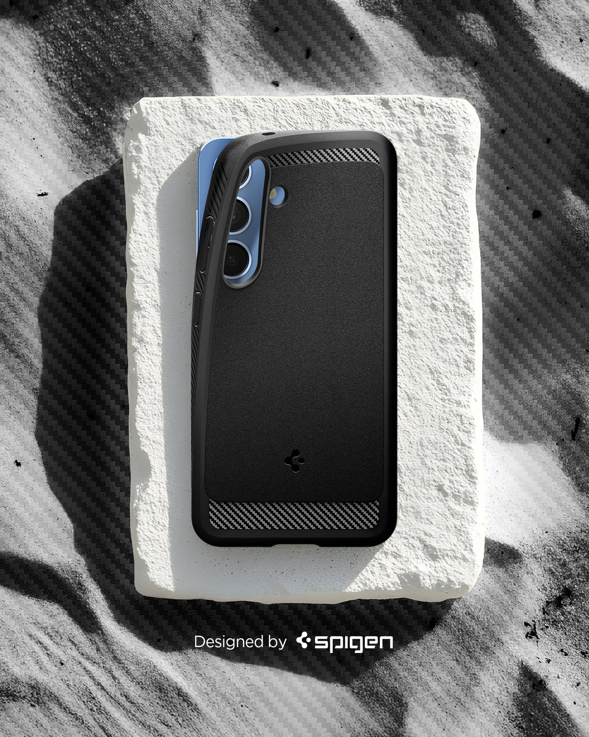 ACS08998 - Galaxy S25 Case Rugged Armor (MagFit) in Matte Black designed by spigen. Showing the phone with the pattern on the sand. 