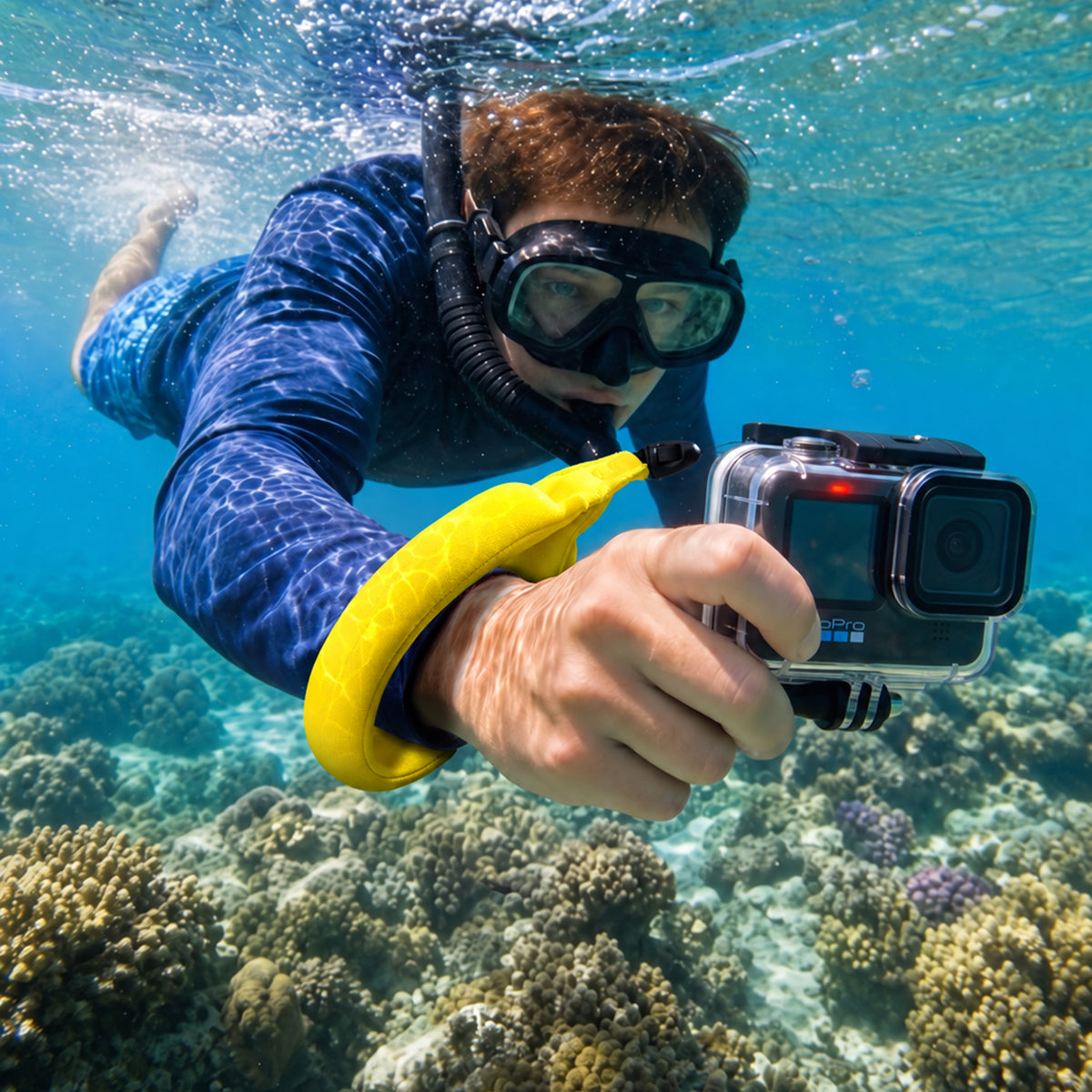 AMP11843 - Aqua Shield Floating Strap in Neon Yellow showing a person underwater wearing a floating wrist strap while holding an action camera