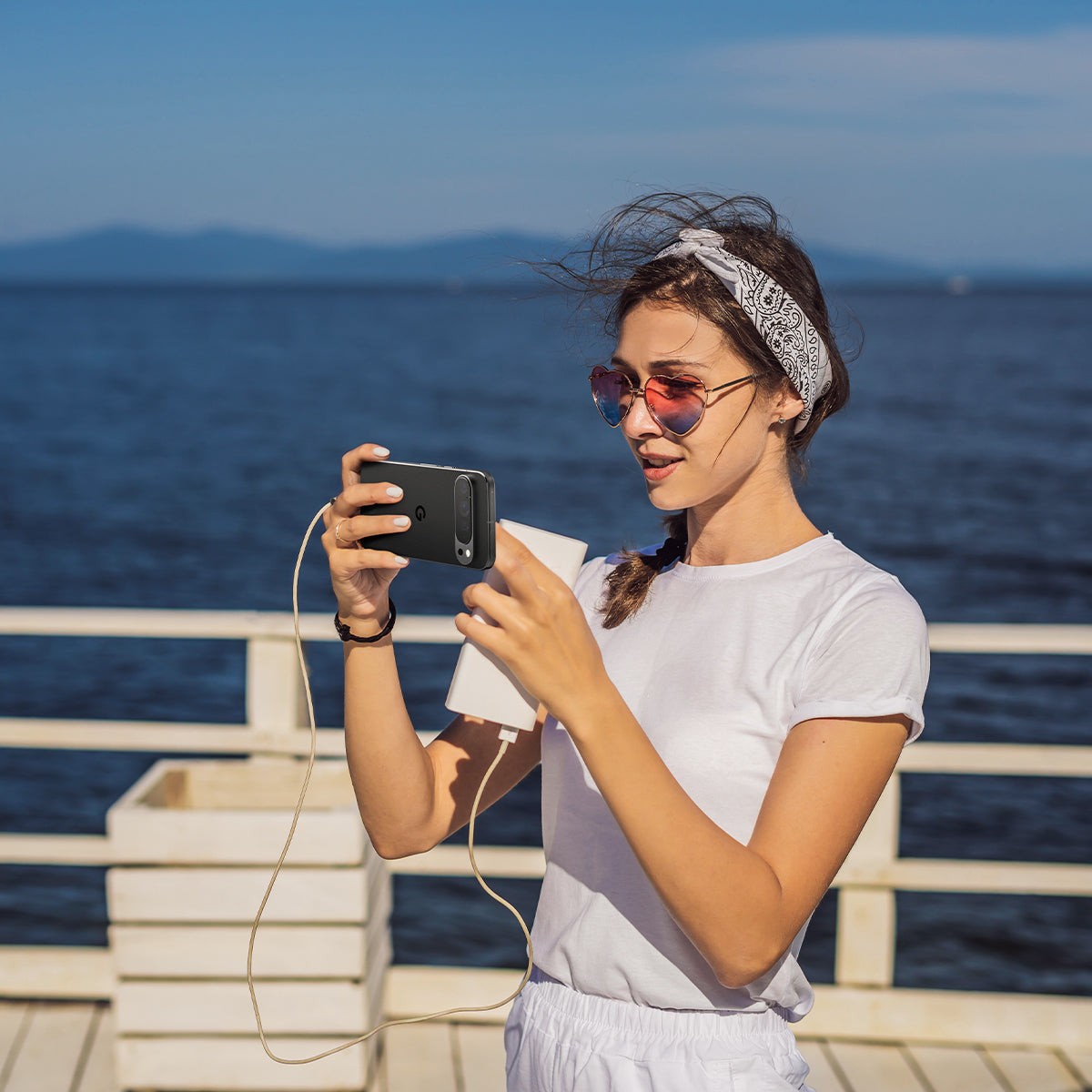 AGL08443 - Pixel 9 Case Optik EZ Fit Lens Protector in Crystal Clear showing a woman holding the device with the installed lens protector